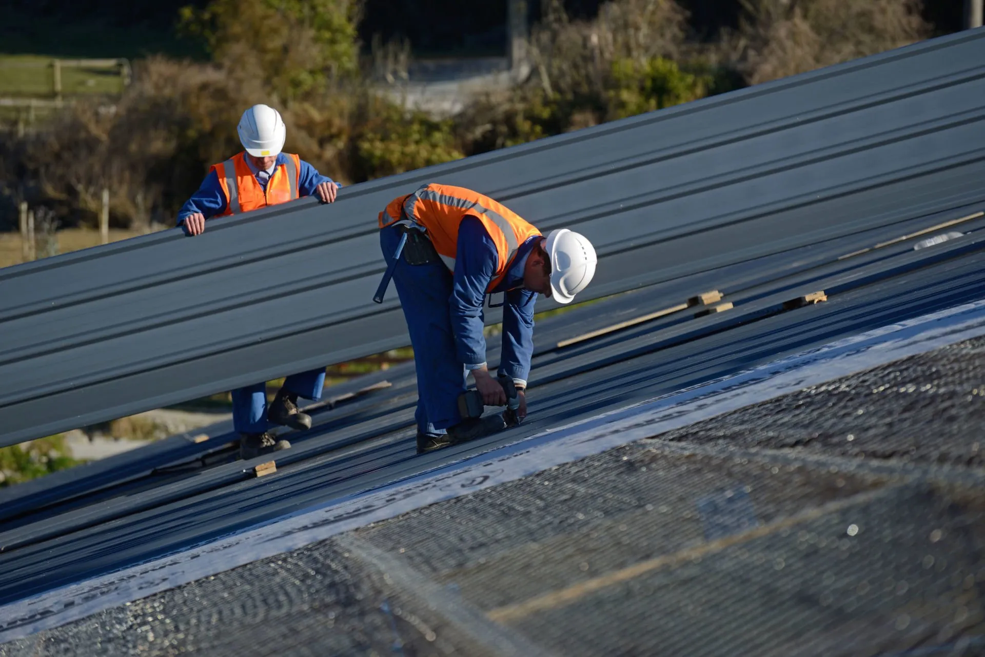 Roofers repairing shingles on a residential roof