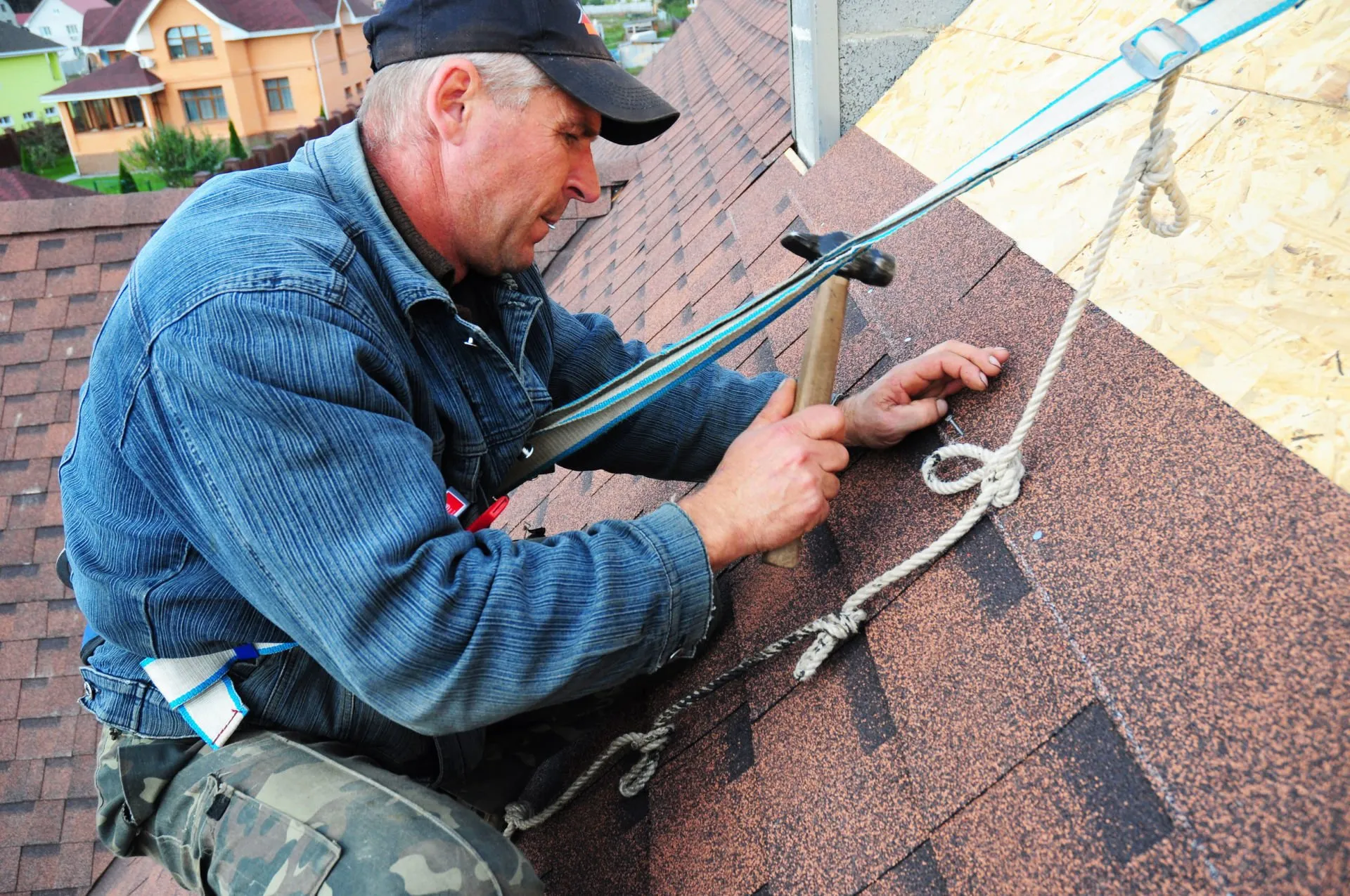 Roofing subcontractor crew working on a new construction site Roofers repairing shingles on a residential roof