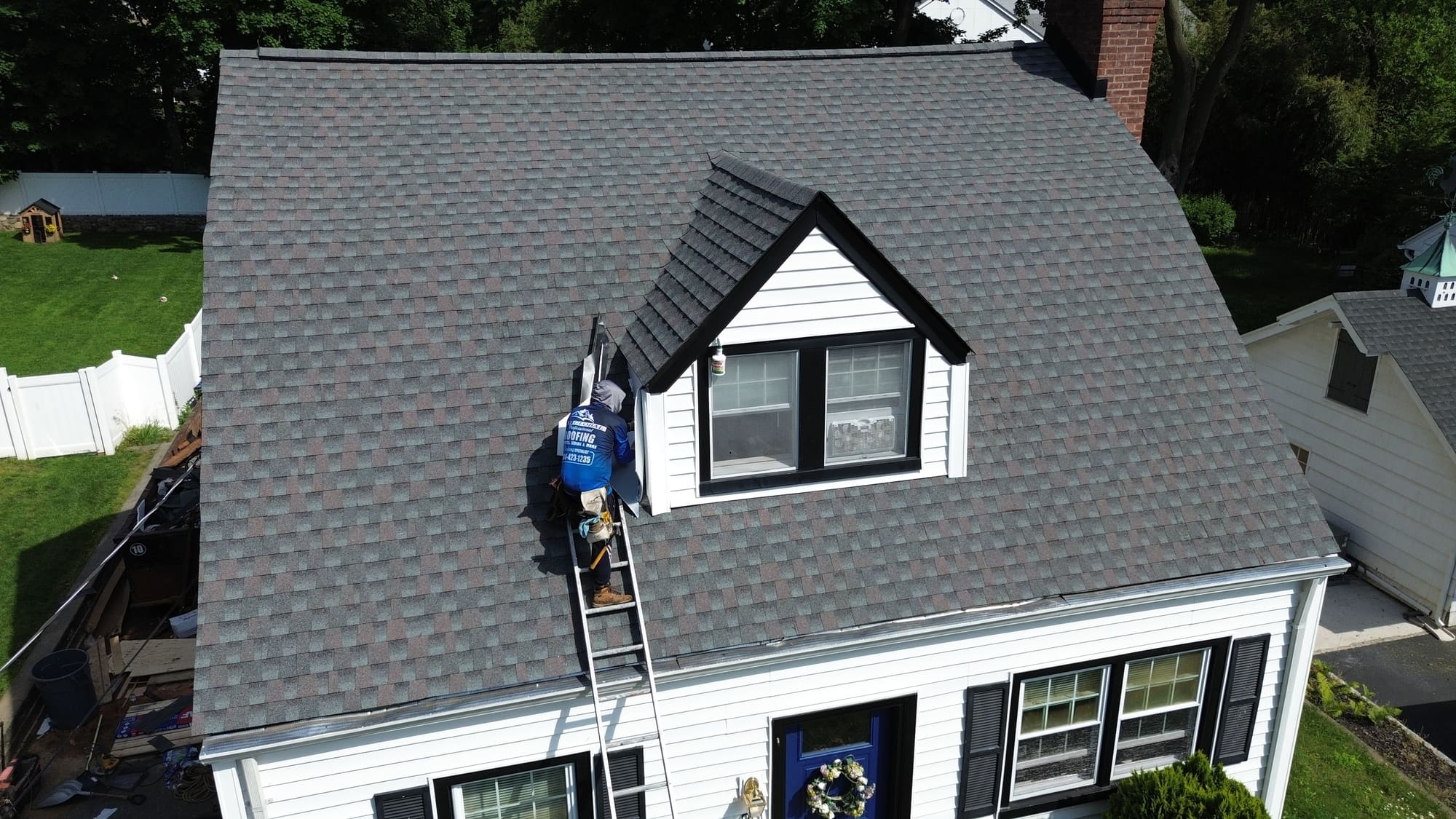 Roof replacement cost in New Jersey: aerial view of a roof replacement in progress
