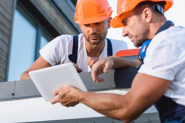 Roofer documenting storm damage on a tablet for an insurance claim